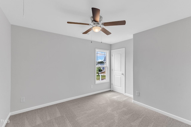 carpeted empty room featuring baseboards and ceiling fan