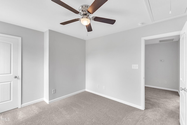 unfurnished bedroom featuring carpet floors, baseboards, attic access, and visible vents