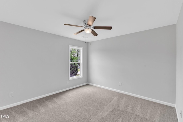 carpeted empty room with a ceiling fan and baseboards