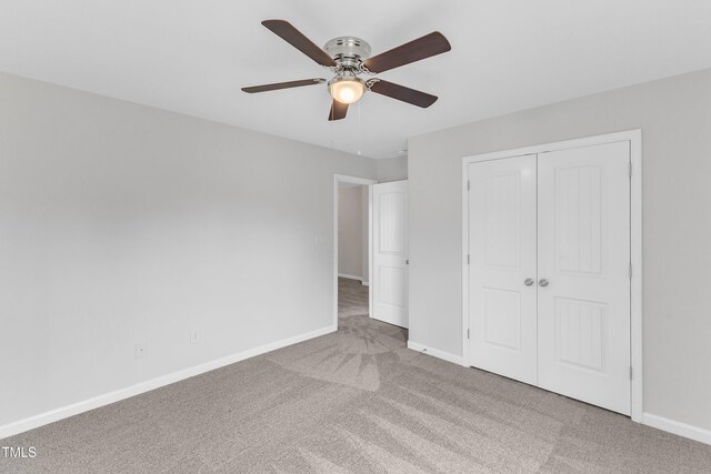 unfurnished bedroom with carpet floors, baseboards, a ceiling fan, and a closet