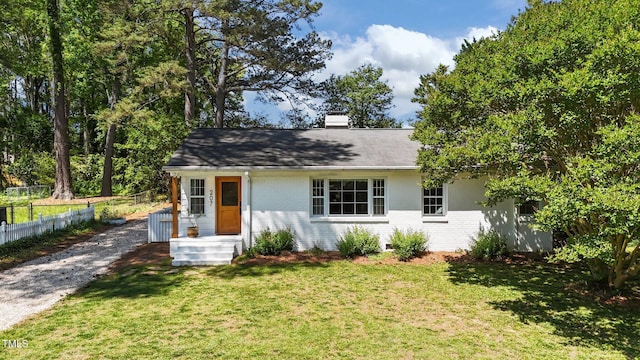 207 N Aiken St, Fuquay Varina, NC 27526 - view of front facade featuring brick siding, fence, a front yard, and a chimney