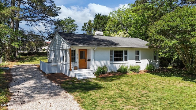 207 N Aiken St, Fuquay Varina, NC 27526 - bungalow-style home with gravel driveway, a front yard, roof with shingles, a chimney, and brick siding