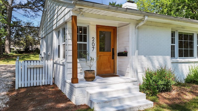 207 N Aiken St, Fuquay Varina, NC 27526 - view of exterior entry featuring brick siding and a chimney