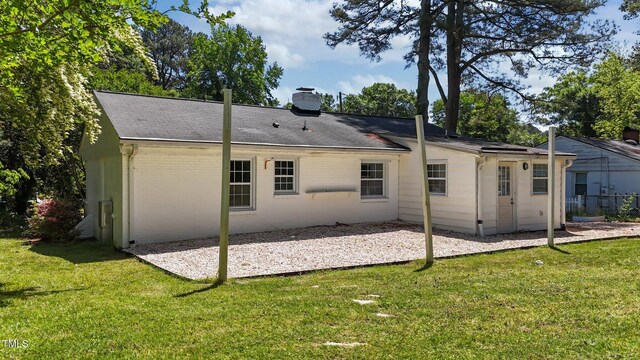 207 N Aiken St, Fuquay Varina, NC 27526 - back of property featuring a lawn, a shingled roof, a patio area, and a chimney