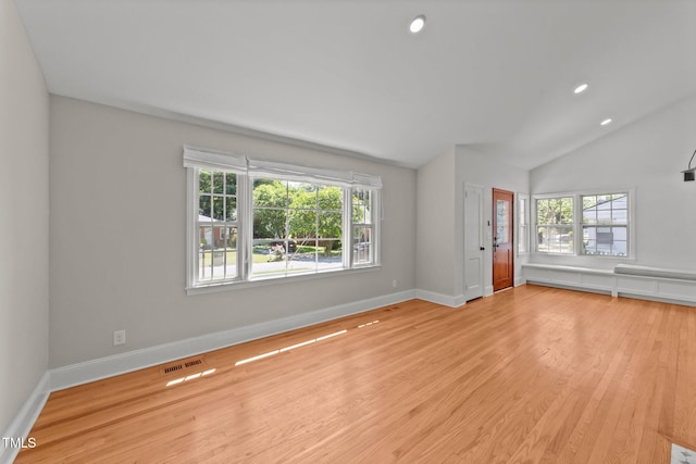 207 N Aiken St, Fuquay Varina, NC 27526 - unfurnished living room with baseboards, vaulted ceiling, wood finished floors, and visible vents