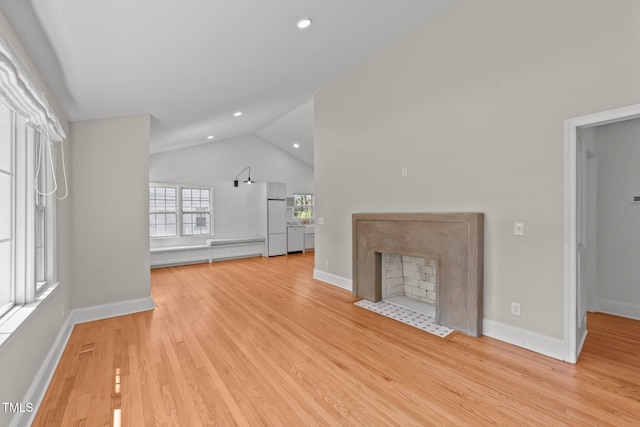 207 N Aiken St, Fuquay Varina, NC 27526 - unfurnished living room featuring baseboards, light wood-type flooring, recessed lighting, a fireplace with flush hearth, and vaulted ceiling