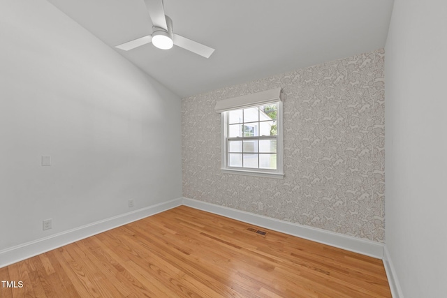 207 N Aiken St, Fuquay Varina, NC 27526 - empty room featuring wallpapered walls, visible vents, wood finished floors, and vaulted ceiling with skylight
