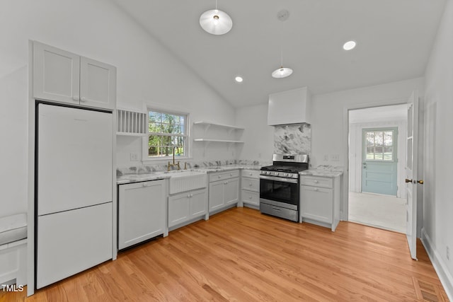 207 N Aiken St, Fuquay Varina, NC 27526 - kitchen featuring plenty of natural light, white refrigerator, open shelves, a sink, and stainless steel gas range