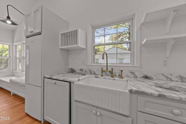207 N Aiken St, Fuquay Varina, NC 27526 - kitchen featuring light stone countertops, open shelves, light wood-type flooring, a sink, and white fridge