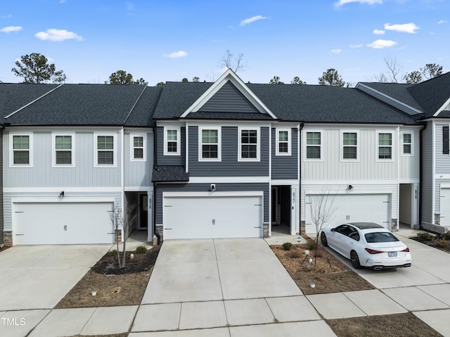 multi unit property with an attached garage, driveway, stone siding, and roof with shingles