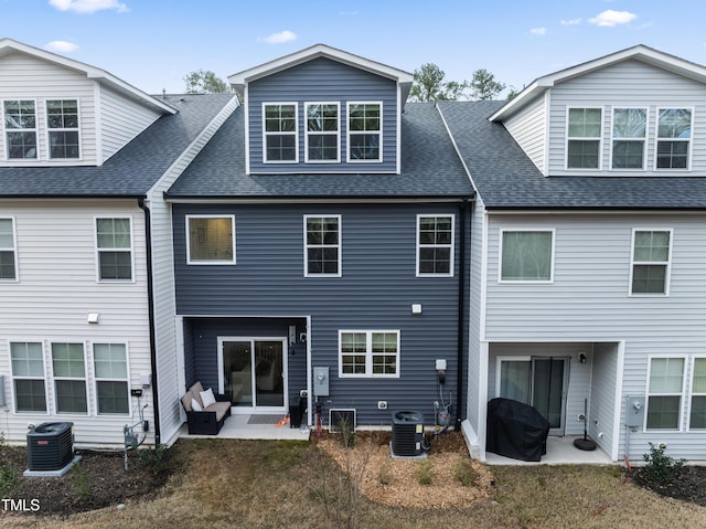 rear view of house featuring a patio area, central AC, and roof with shingles
