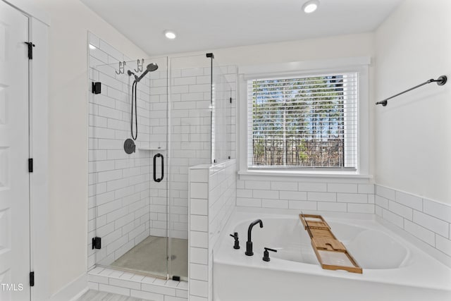 bathroom featuring a stall shower, a bath, and recessed lighting