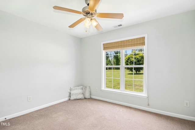 carpeted empty room featuring baseboards and a ceiling fan