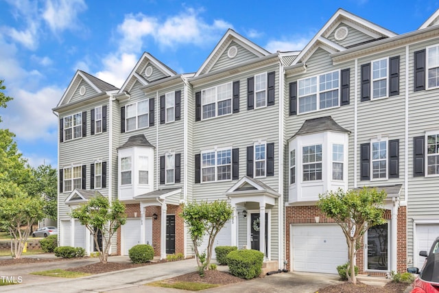 2705 Wyntercrest Ln, Durham, NC 27713 - townhome / multi-family property featuring concrete driveway, brick siding, and a garage
