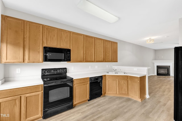 2705 Wyntercrest Ln, Durham, NC 27713 - kitchen featuring light wood-type flooring, a sink, black appliances, a peninsula, and open floor plan