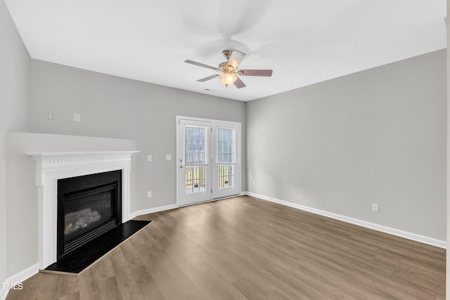 2705 Wyntercrest Ln, Durham, NC 27713 - unfurnished living room featuring a ceiling fan, baseboards, a glass covered fireplace, and wood finished floors