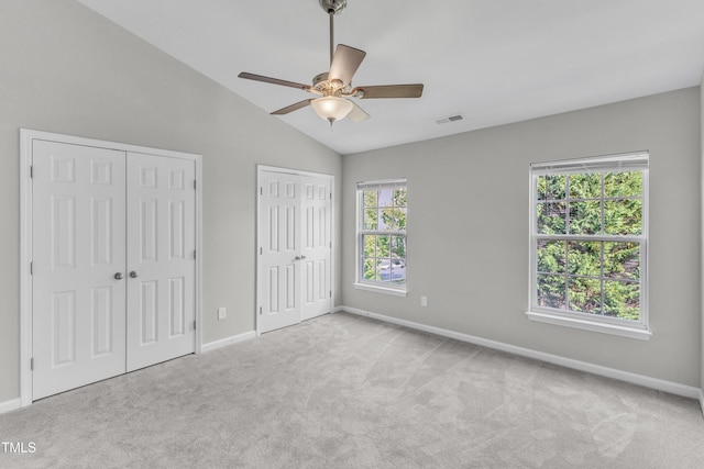 2705 Wyntercrest Ln, Durham, NC 27713 - unfurnished bedroom with visible vents, baseboards, two closets, lofted ceiling, and carpet flooring