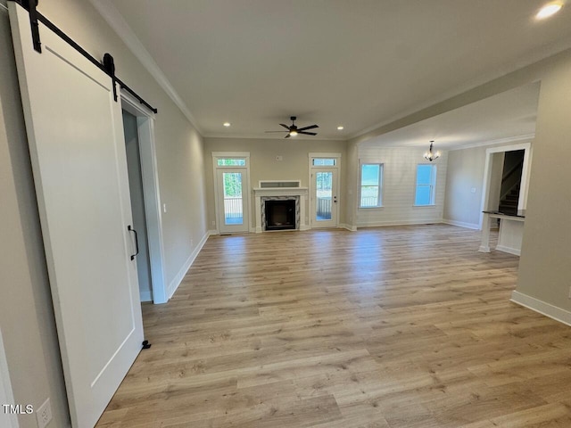 27 Batten Hill Ln, Selma, NC 27576 - unfurnished living room featuring a barn door, crown molding, a ceiling fan, recessed lighting, and light wood-type flooring