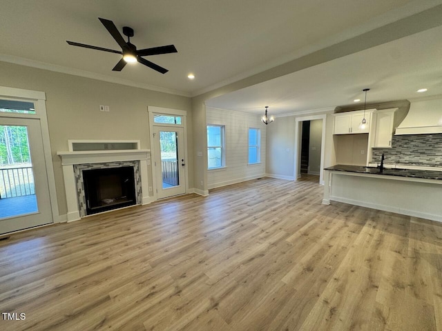 27 Batten Hill Ln, Selma, NC 27576 - unfurnished living room with crown molding, healthy amount of natural light, light wood-style flooring, a high end fireplace, and recessed lighting