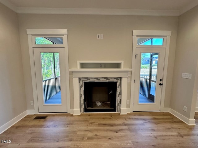 27 Batten Hill Ln, Selma, NC 27576 - unfurnished living room featuring ornamental molding, a fireplace, plenty of natural light, and wood finished floors