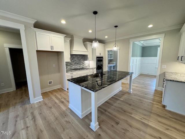 27 Batten Hill Ln, Selma, NC 27576 - kitchen with premium range hood, black stovetop, crown molding, white cabinets, and decorative backsplash