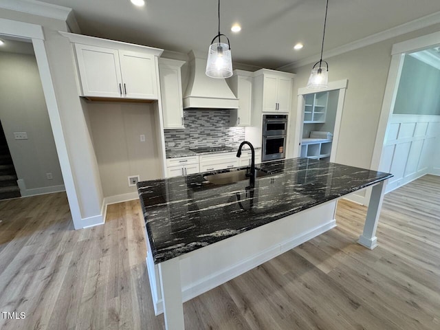 27 Batten Hill Ln, Selma, NC 27576 - kitchen with double oven, crown molding, custom exhaust hood, light wood-style flooring, and white cabinetry