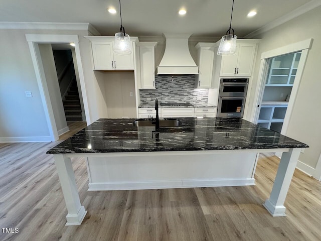 27 Batten Hill Ln, Selma, NC 27576 - kitchen featuring custom exhaust hood, stainless steel double oven, white cabinets, light wood-type flooring, and crown molding