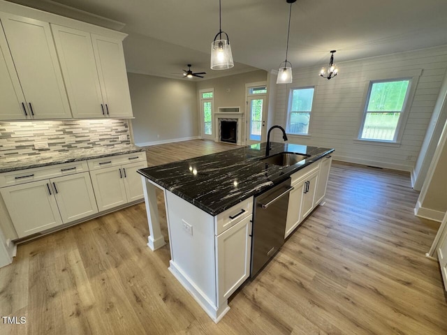 27 Batten Hill Ln, Selma, NC 27576 - kitchen with dishwasher, a fireplace, light wood-type flooring, ceiling fan, and tasteful backsplash