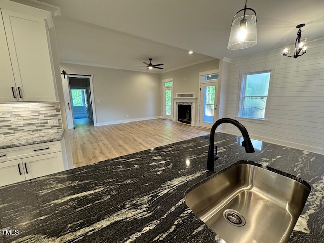 27 Batten Hill Ln, Selma, NC 27576 - kitchen with crown molding, light wood-style floors, decorative backsplash, a ceiling fan, and white cabinetry
