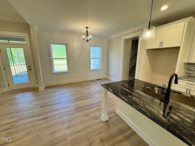 27 Batten Hill Ln, Selma, NC 27576 - kitchen featuring ornamental molding, plenty of natural light, dark stone counters, white cabinetry, and light wood-style flooring