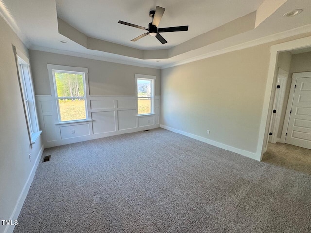 27 Batten Hill Ln, Selma, NC 27576 - unfurnished room with a tray ceiling, a ceiling fan, light colored carpet, wainscoting, and ornamental molding