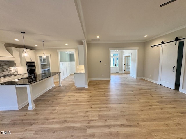 27 Batten Hill Ln, Selma, NC 27576 - kitchen with custom exhaust hood, crown molding, a barn door, white cabinets, and recessed lighting