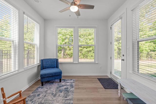 sitting room featuring baseboards, ceiling fan, plenty of natural light, and wood finished floors