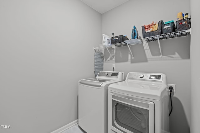 washroom with separate washer and dryer, baseboards, and laundry area