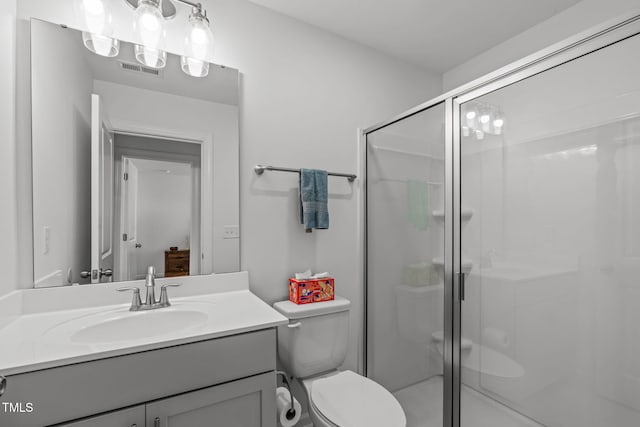 bathroom with vanity, toilet, visible vents, and a stall shower
