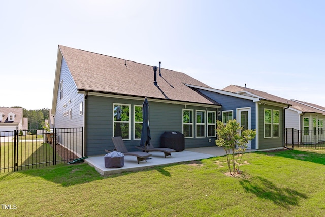 rear view of house featuring a yard, a patio, a fenced backyard, and roof with shingles