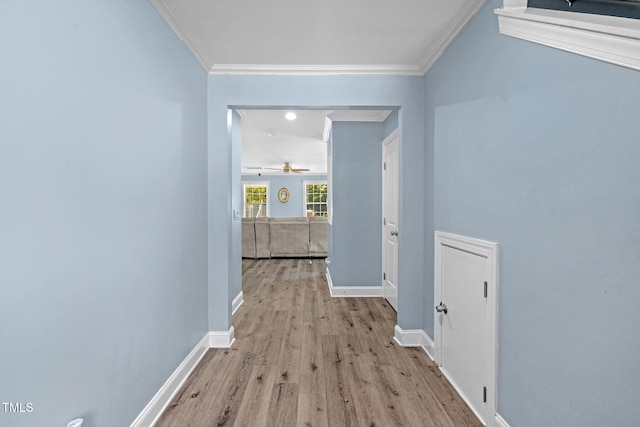 corridor with crown molding, baseboards, and wood finished floors