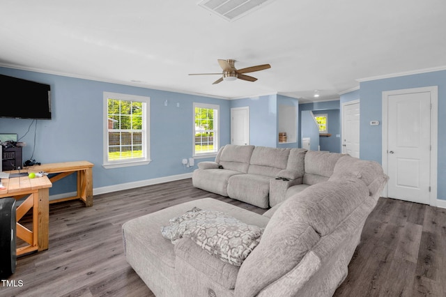 living room with crown molding, baseboards, visible vents, and wood finished floors
