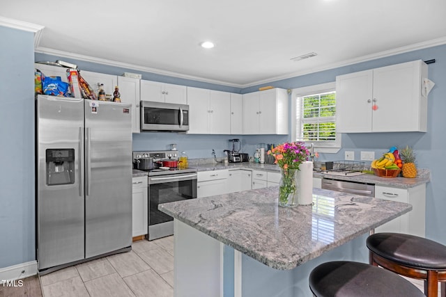kitchen featuring crown molding, white cabinets, and stainless steel appliances