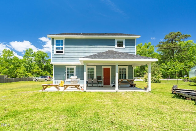 rear view of house featuring fence and a yard