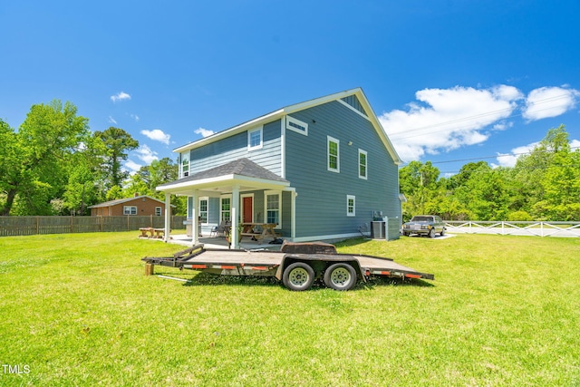 rear view of property featuring a lawn, a fenced backyard, and a patio area