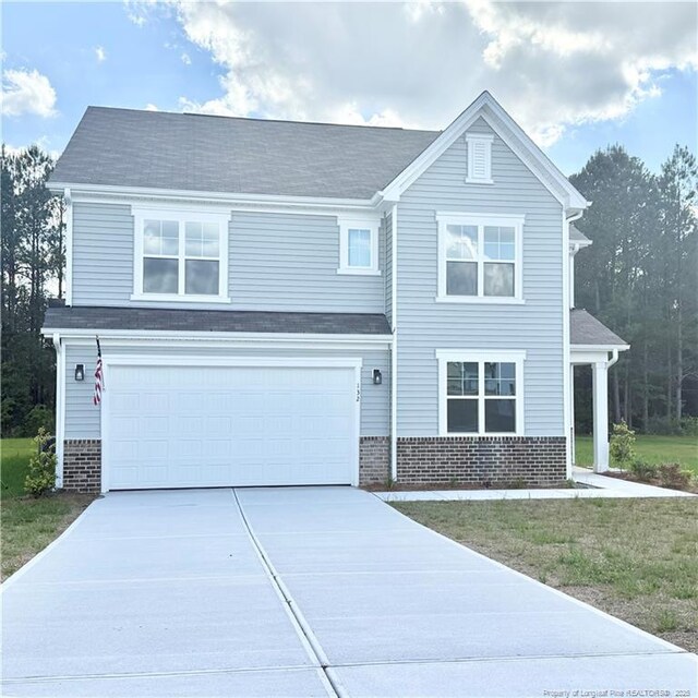 132 Cahill, Home, Raeford, NC 28376 - view of front of property featuring brick siding, driveway, an attached garage, and a front lawn