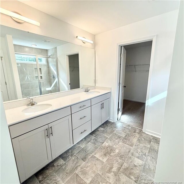 132 Cahill, Home, Raeford, NC 28376 - bathroom with a shower stall, a spacious closet, double vanity, stone finish floors, and baseboards