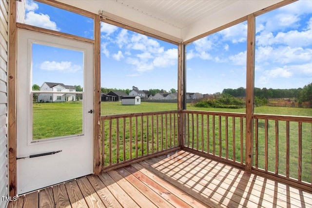 wooden deck featuring a residential view, a yard, and an outbuilding