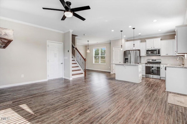 unfurnished living room featuring recessed lighting, stairs, ornamental molding, baseboards, and dark wood-style floors