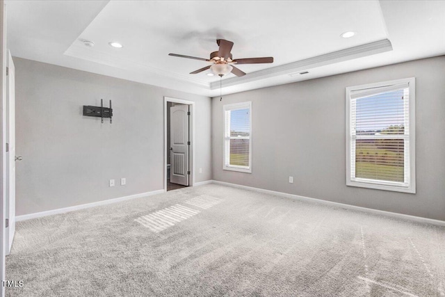 carpeted empty room featuring recessed lighting, ceiling fan, baseboards, visible vents, and a raised ceiling