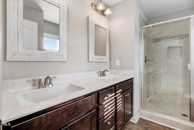 full bath featuring a stall shower, double vanity, and a sink
