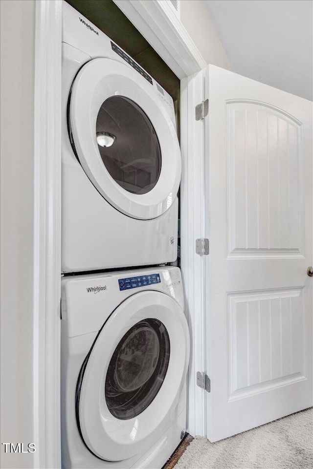 laundry room featuring stacked washing maching and dryer, carpet floors, and laundry area