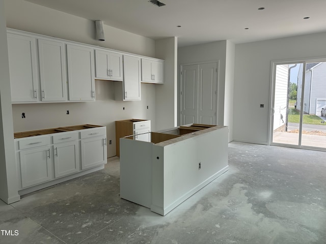 2874 Quarry Rd Unit 165, Rolesville, NC 27571 - kitchen featuring unfinished concrete flooring, white cabinetry, and a center island