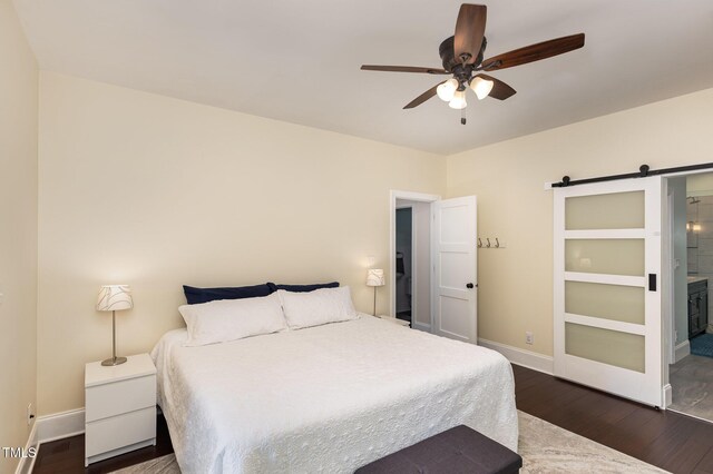 7901 Farnham Ct, Raleigh, NC 27615 - bedroom featuring dark wood-style flooring, ceiling fan, a barn door, baseboards, and ensuite bathroom